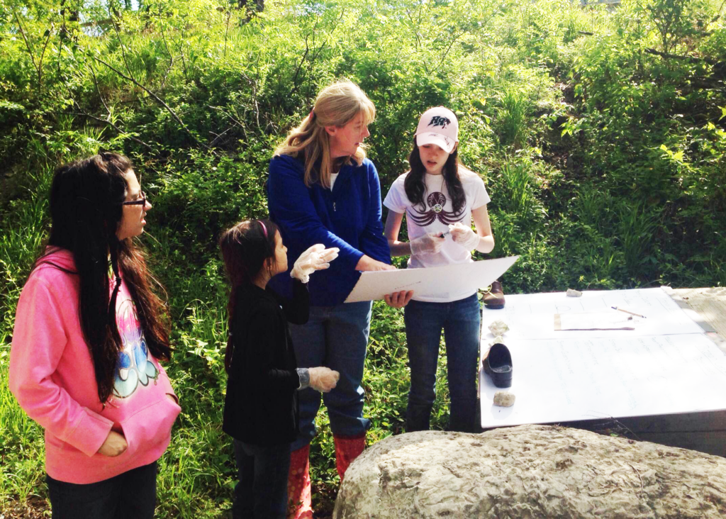 One woman and three girls testing the stream water.